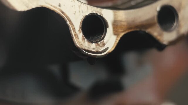 Oil Residue Dripping from Metal Part with Light Reflections