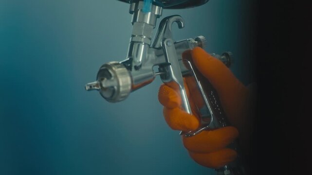 Worker Holding Paint Spray Gun Ready for Vehicle Panel