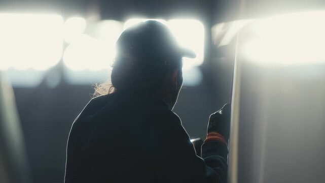 Worker Installing Tram Glass Panel with Backlit Environment
