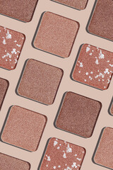 Eyeshadow palette background, mix of matte and shimmer shades brown, beige hues. Aesthetic top view pattern for beauty, makeup, cosmetics themes, Neutral colored swatches eyeshade refills