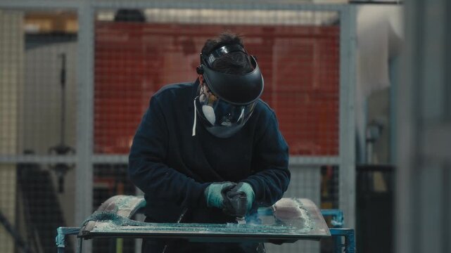 Worker Wearing Safety Gear Scraping Shattered Glass on Table