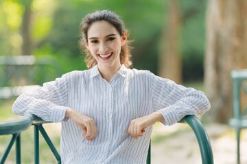 Authentic portrait of a young professional woman smiling confidently, conveying approachability and positive corporate culture outdoors