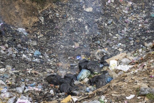 Coking rubbish dump, rubbish pit with waste and plastic rubbish, karst landscape near Vang Vieng, Vientiane province, Laos
