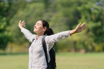 Woman standing outdoors with arms open wide, personal freedom, deep breathing, acceptance, and stress relief for mental wellness