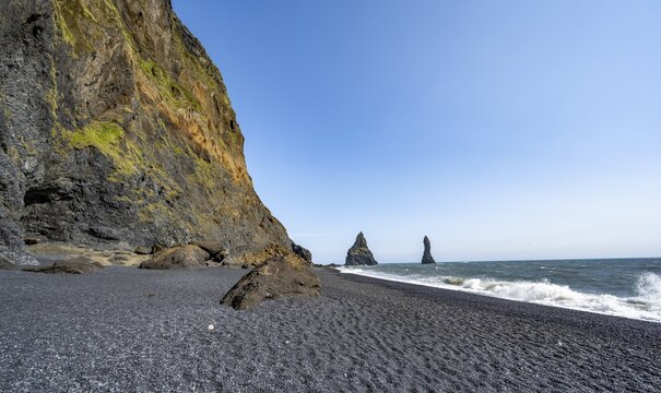 Black beach with cliffs, rock Reynisdrangar in the water, at Reynisfjara beach, Vik, South Iceland, Iceland