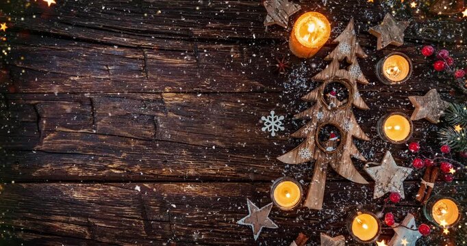 Cozy Christmas decorations arranged on rustic wood with gentle falling snow creating a festive winter atmosphere. Ideal as a holiday background or seasonal backdrop.