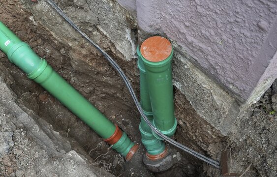 Construction worker, newly laid green sewage pipes, Stuttgart, Baden-W&uuml;rttemberg