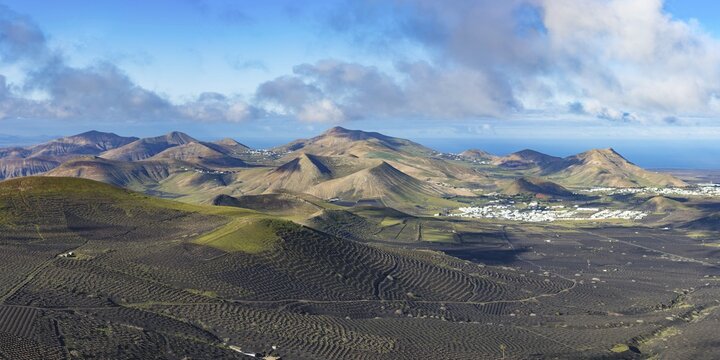 Panorama at sunrise from Montana de Guardilama to the wine-growing region of La Geria, with the villages of Uga and Yaiza behind, Lanzarote, Canary Islands, Spain