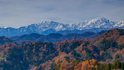 紅葉した里山と冠雪した北アルプス　長野県小川村　絶景 © Yuuki Kobayashi