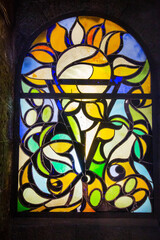 The stained glass window is bright and beautiful in the form of a sunflower flower in yellow, green and blue. Global tourism and technology.