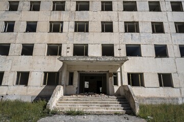 Entrance to an abandoned ruined residential building, old Soviet apartment block in the ghost town, Engilchek, Tian Shan, Kyrgyzstan