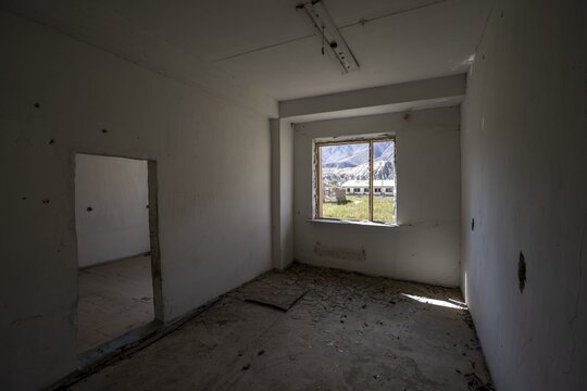 An abandoned, dilapidated room with a view of the mountains through the window, ghost town, Engilchek, Tian Shan, Kyrgyzstan
