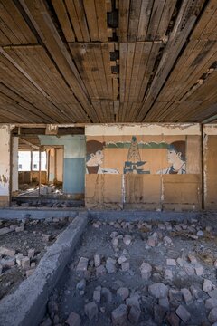 Destroyed abandoned classroom of the old school, wall painting with Soviet miners, ghost town, Engilchek, Tian Shan, Kyrgyzstan