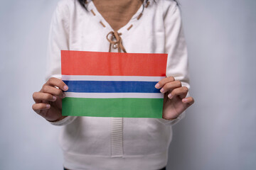 Person Holding Gambia National Flag Against Neutral Background