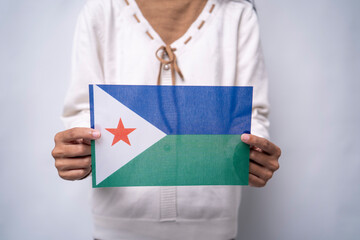 Person Holding Djibouti National Flag Against Neutral Background