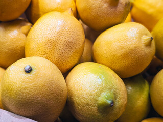 close up of a vibrant pile of fresh yellow citrus lemons