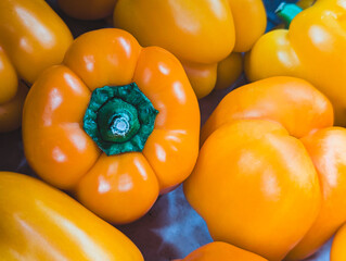 close up of vibrant yellow bell pepper with green stem detail