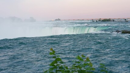 Aerial perspective of Niagara Falls in Ontario showcasing flowing water and greenery in summer