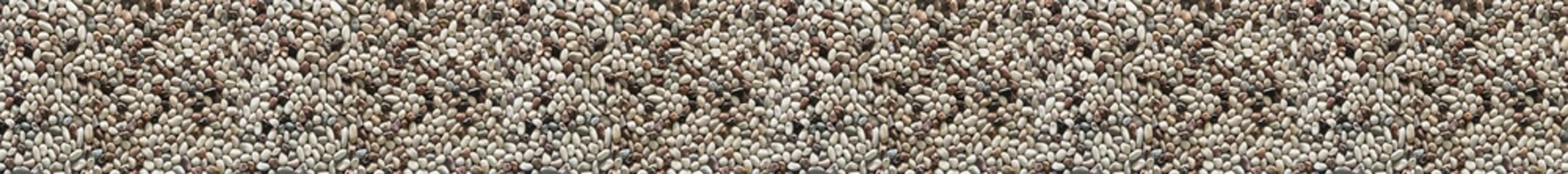 Pebble stone background with small smooth gray and beige river stones forming seamless natural...