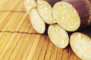 Close up sugarcane sticks on bamboo background.