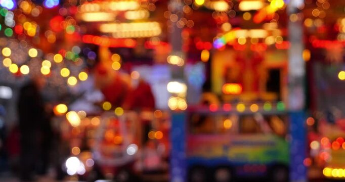 brightly colored, blurry market stall with flashing lights in the evening, background for christmas, city festivals, and events with copy space