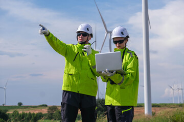 Engineers monitor wind farm operations while discussing data and exceeding safety protocols at a renewable energy site