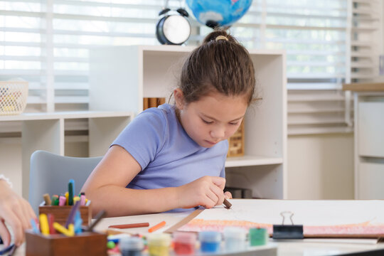Caucasian elementary girl student carefully drawing with crayons at classroom desk representing creativity imagination dedication artistic expression educational growth childhood positive learning - Powered by Adobe