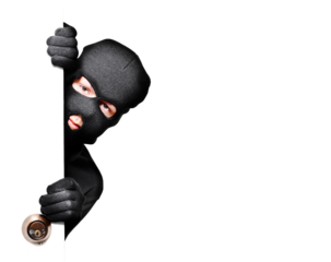 Masked burglar peeking through a door holding the handle creating a tense security and home intrusion concept