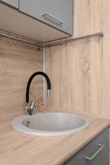 Modern kitchen interior with an artificial stone sink and a wood-like countertop