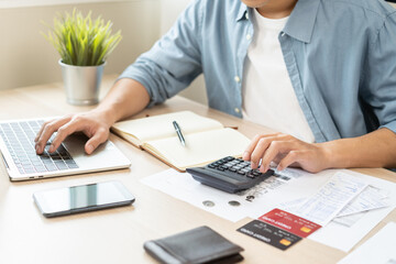 Account finance, asian young business man hand using calculator, laptop computer for calculate...