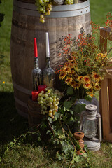 Rustic Wedding Decor With Grapes, Candles and Flowers on Wooden Barrel