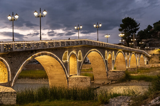 Spazierg&auml;nger auf beleuchteter Steinbr&uuml;cke mit Laternen, Berat, Albanien