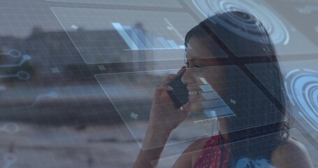 Smiling woman in sleeveless red top holding smartphone to ear at workspace, HUD, copy space