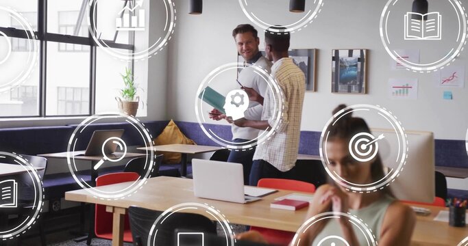 Talking team in business-casual checking teal folder and typing on laptop in coworking space, icons