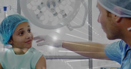 Reaching gloved doc in scrubs touching teal-capped child on bed under overhead light, copy space