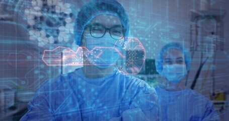 Standing central male surgeon wearing glasses and blue gown in operating room, showing digital key