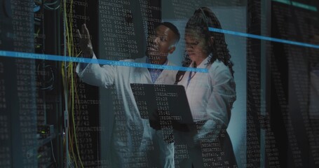 Pointing techs in white lab coats inspecting data center server racks, holding laptop, patch cables