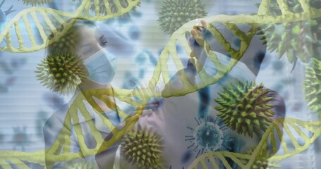 Two masked clinicians reviewing scans in clinic in lab coats with stethoscope, DNA virus blinds