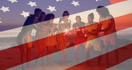 Smiling eight adults cheering at beach dusk in casual wear, holding sparklers under US flag overlay