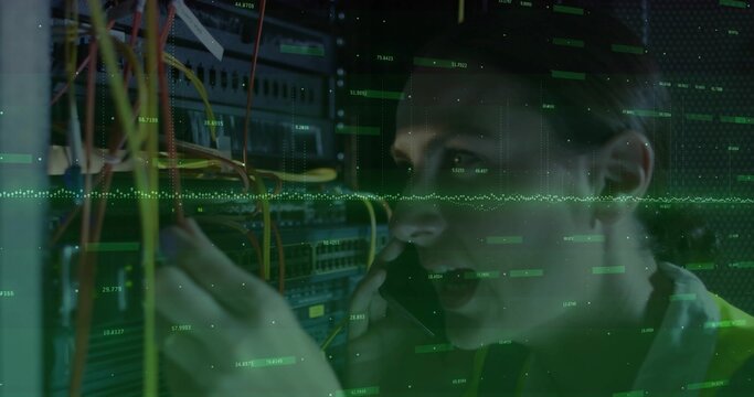 Fixing female tech wearing hi-vis vest, holding phone and rerouting Ethernet cables at server rack