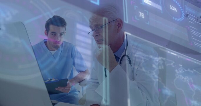 Doctor in white lab coat and junior in blue scrubs consulting in clinic, reviewing HUD monitor