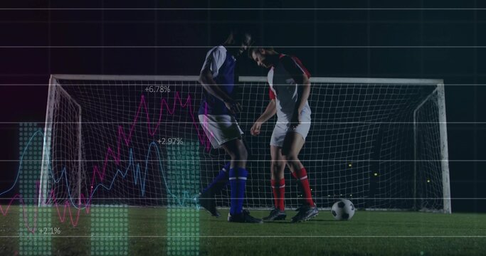 Standing soccer players wearing contrasting kits on night pitch by goal with ball floodlights data