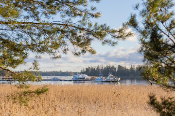 Small boat marina of Espoo, Finland with motorboats moored, docked at the pier and tied to mooring buoys or finger pier
