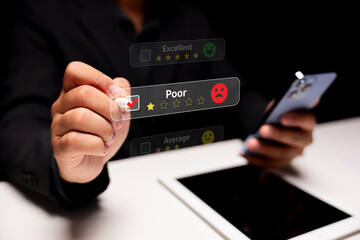 A hand selects a poor rating on a digital review interface, showcasing feedback and user interaction with a smartphone in a dark setting.