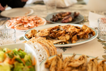 Close-up of a plate of fried sea bass on the table, ready to be eaten with the family; recipes and healthy dishes from homemade seafood and fish
