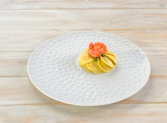 A beautifully crafted plate of Griasoli pasta is showcased on a textured white dish. Topped with delicate shrimp, it offers a vibrant splash of color, inviting culinary pleasure