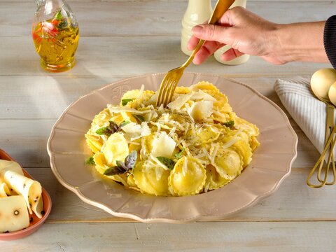 Delicious griasoli pasta is being served on a light, rustic plate. Fresh herbs and cheese adorn the dish, creating a warm, inviting atmosphere for a family gathering at dinner time