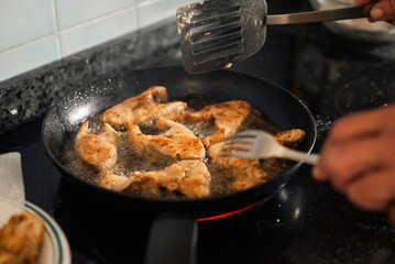 Family Cooking Seafood – Frying Corvina on Ceramic Stove