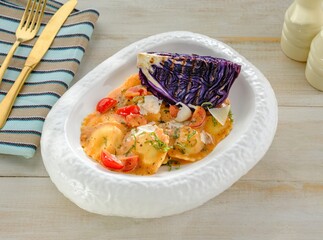A beautifully arranged bowl displays Griasoli pasta, topped with cherry tomatoes and a purple...