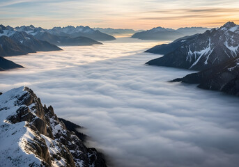 Stunning aerial view of mountain peaks emerging from a sea of clouds at dawn, creating a majestic panorama